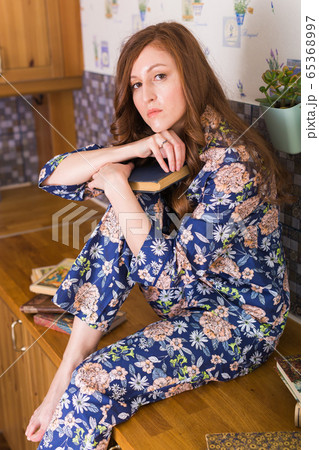 Young red-haired woman relaxing at home reading book. Quarantine, isolation, coronavirus pandemic world. Stay at home. Young red-haired woman relaxing at home reading book. Quarantine, isolation, coronavirus pandemic world. Stay at home. 65368997
