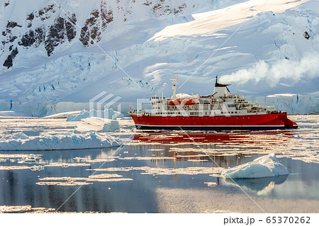 Red cruise steamboat drifting among the icebergs Red cruise steamboat drifting among the icebergs 65370262