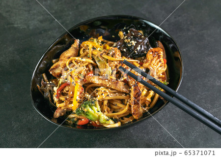 Asian noodles with meat on plate 65371071