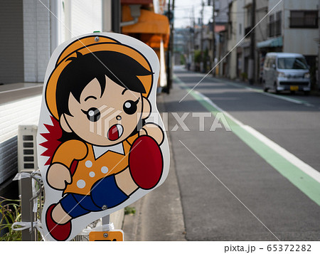 交通量の多い住宅街に置かれている飛び出し坊やの看板 65372282