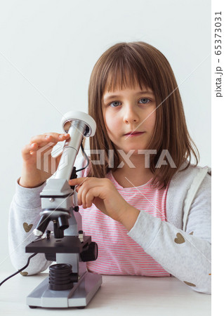 Child girl in science class using digital microscope. Technologies, children and learning concept. 65373031