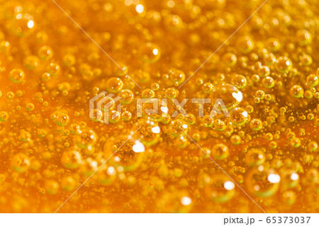 Liquid yellow paste for sugaring close-up. Depilation and hair removal concept. Macro photo. Liquid yellow paste for sugaring close-up. Depilation and hair removal concept. Macro photo. 65373037