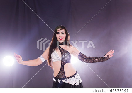 Young woman dancing in Tribal Fusion style. Belly dance on the stage. 65373597