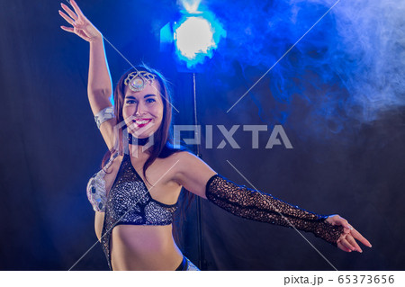 Young woman dancing in Tribal Fusion style. Belly dance on the stage. 65373656