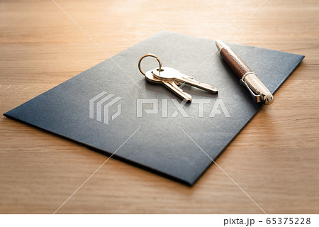 Keys, pen and envelope on the wooden table. Selling or rental of flat, house or another real estate or object. Symbol of agreement Keys, pen and envelope on the wooden table. Selling or rental of flat, house or another real estate or object. Symbol of agreement 65375228