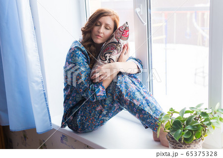 Young red-haired woman relaxing at home. Quarantine, isolation, coronavirus pandemic world. Stay at home. 65375328