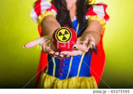 Woman holding hazardous radioactive apple. Nuclear and radiation measurement concept, close-up. 65375595