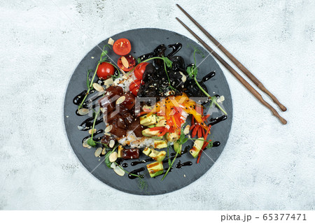 Hawaiian salmon fish poke bowl with rice, radish,cucumber, tomato, sesame seeds and seaweeds. Buddha bowl. Diet food 65377471