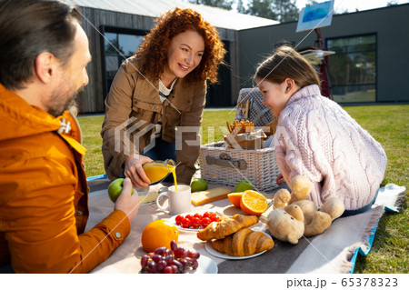 Happy family eating and chatting outside the city Happy family eating and chatting outside the city 65378323