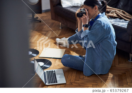 Caucasian cute woman using camera at home Caucasian cute woman using camera at home 65379267