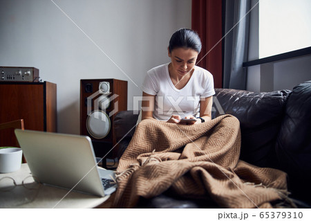 Beautiful lady sitting on coach in her apartment Beautiful lady sitting on coach in her apartment 65379310