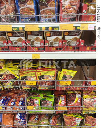 The spices are sold in commercial packages and are displayed on shelves in the supermarket. Sort by brand and type to make it easier for customers to buy. 65379414