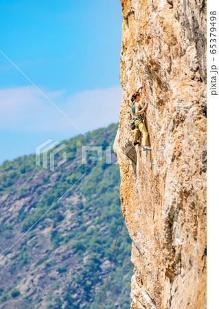 Woman climbs a rock. Woman climbs a rock. 65379498