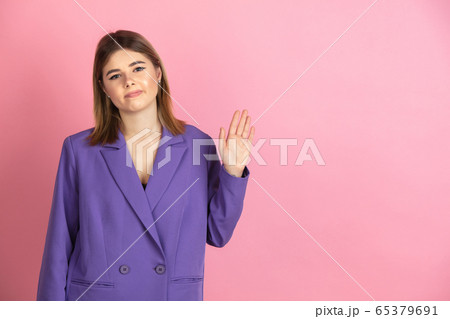 Caucasian young woman's portrait on pink studio background, emotional and expressive 65379691