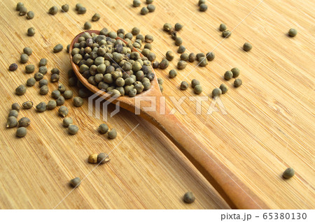 Dried okra seeds in wooden spoon, on bamboo Dried okra seeds in wooden spoon, on bamboo 65380130