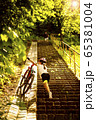 9 years girl bring up for the stairs her bicycle in the sunny day 65381004
