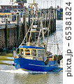 A small fishing boat enters the harbour of Busum in North Frisia in Germany. 65381824