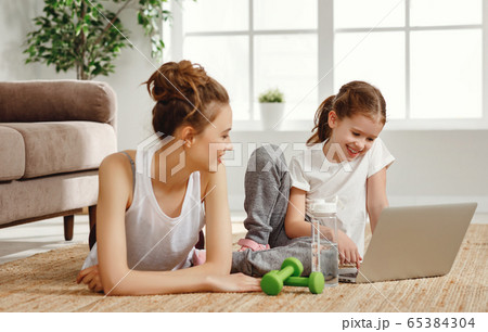 Cheerful woman with daughter using laptop during Cheerful woman with daughter using laptop during 65384304