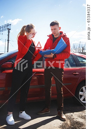 Driving instructor and woman student in examination car. 65384337