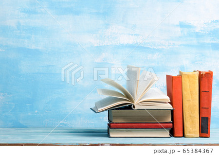 Composition with vintage old hardback books, diary, fanned pages on wooden deck table and abstract background. Books stacking. Back to school. Copy Space. Education background. Composition with vintage old hardback books, diary, fanned pages on wooden deck table and abstract background. Books stacking. Back to school. Copy Space. Education background. 65384367