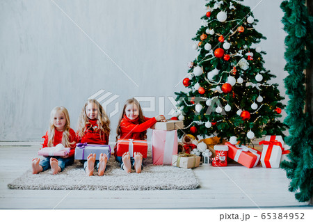 Christmas holiday three girl with gifts the new year tree decoration on a grey background gifts Christmas holiday three girl with gifts the new year tree decoration on a grey background gifts 65384952