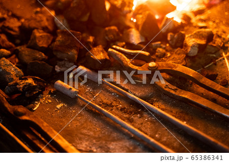 Grungy tools inside furnace in smithy from above 65386341