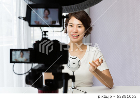 一眼レフカメラで動画を撮影する女性 65391055