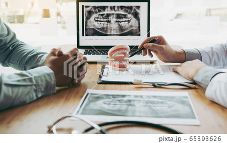 Dentist hand pointing x-ray picture in laptop 65393626