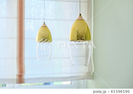 Interior home design, two modern gold-colored glass lamps over the dining table 65396590
