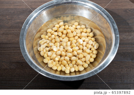 乾燥大豆を水に浸してやわらかくする過程(納豆づくりの最初の過程) 乾燥大豆を水に浸してやわらかくする過程(納豆づくりの最初の過程) 65397892