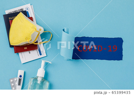 Coronavirus and travel concept. Passports, airplane tickets, sanitizer, thermometer and medical mask flat lay 65399435