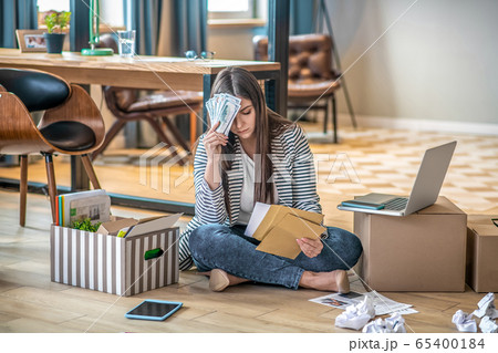 Young woman sitting on the floor and feeling desperate Young woman sitting on the floor and feeling desperate 65400184