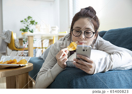 リビングでごろごろする女性 65400823