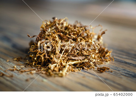 Cut tobacco leaves on the wooden background 65402000