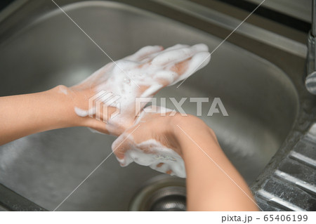 Woman washing hands in a sink with tap water Woman washing hands in a sink with tap water 65406199