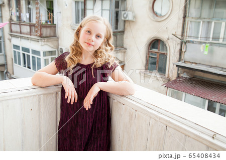 Portrait of a beautiful little blonde girl in a dark dress 65408434
