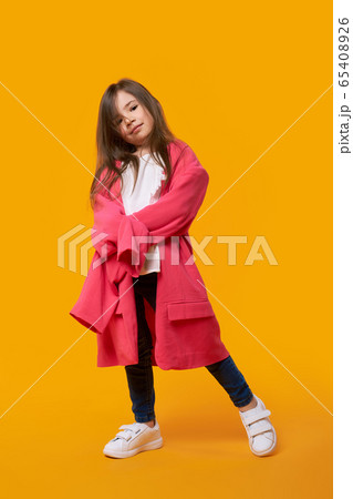 Happy young girl wearing jacket of her mother and fooling around 65408926