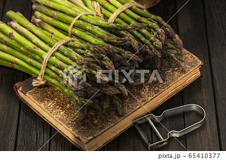 Bunch of fresh green asparagus spears on a rustic wooden table Bunch of fresh green asparagus spears on a rustic wooden table 65410377