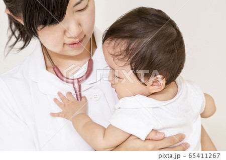 赤ちゃんを抱き世話をする白衣の看護師 赤ちゃんを抱き世話をする白衣の看護師 65411267