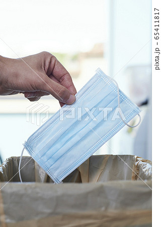 man throwing a surgical mask to the trash can 65411817