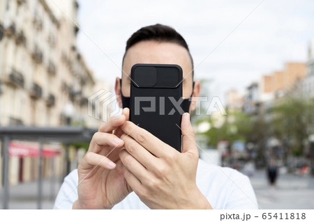 man wearing mask taking selfie or doing video call man wearing mask taking selfie or doing video call 65411818