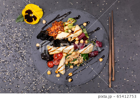 Vegan tofu poke bowls with seaweed, watermelon radish, cucumber, edamame beans and rice noodles. 65412753
