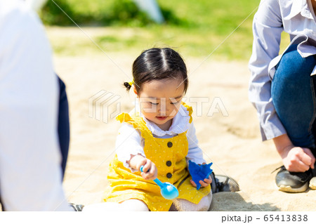幼児 公園 家族 砂場で遊ぶ可愛い女の子の写真素材