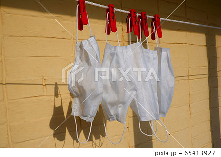Washed white medical masks hanging on clothesline 65413927