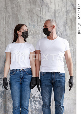 A married couple in black meedsin masks and black rubber gloves. 65415147