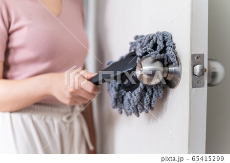 Close up young Asian woman holding dust wiper cleaning house door 65415299