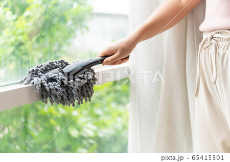 Close up young Asian woman holding dust wiper cleaning house window 65415301