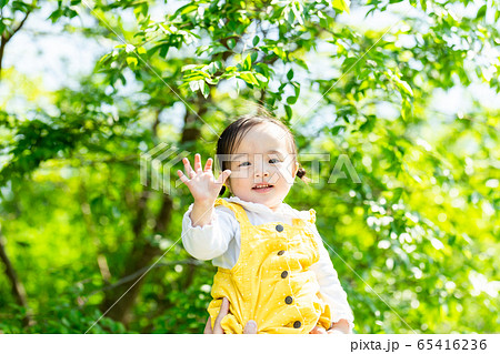 幼児 公園 幸せな家族 パパに抱かれる可愛い女の子 の写真素材