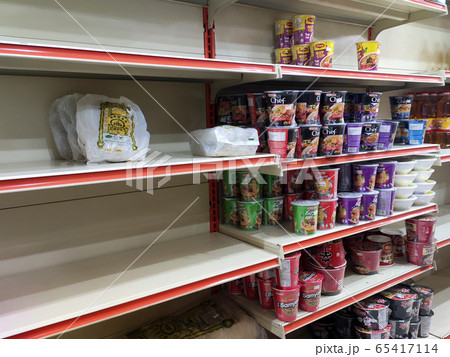 The shelves at the supermarket became empty due to panic buying. Customers buy necessities in excessive quantities resulting in stock depletion. 65417114