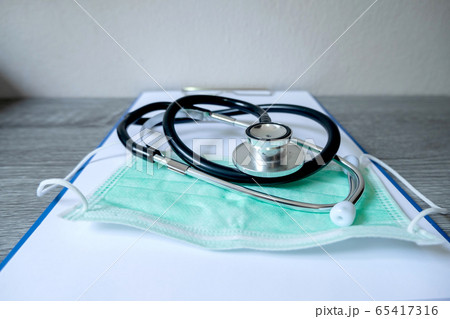 Pictures of medical surgical masks and stethoscope are on the prescription documents in the hospital dispensing room Pictures of medical surgical masks and stethoscope are on the prescription documents in the hospital dispensing room 65417316